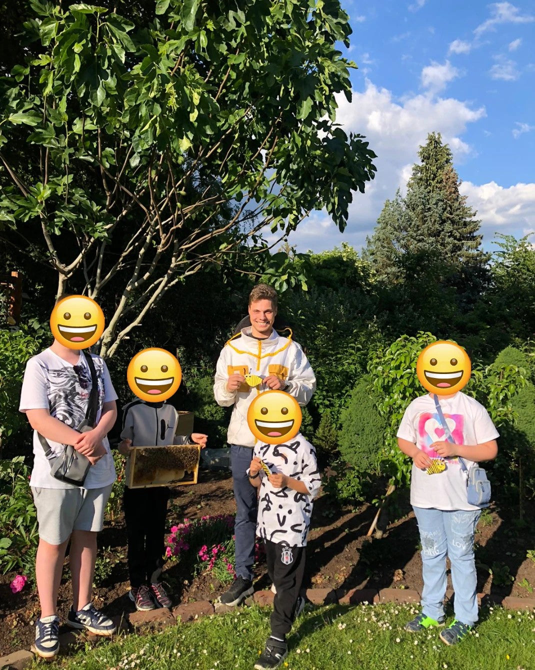 Imker Philipp Harde mit Kindern der Dortmunder Tafel beim Bienenkurs im Garten